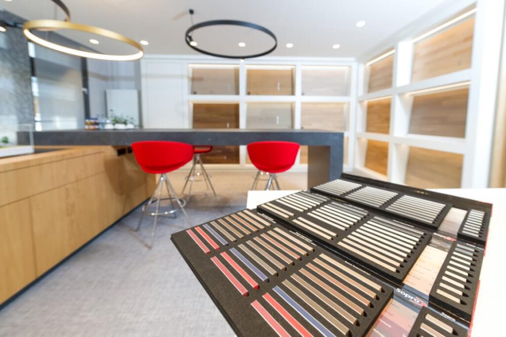 Musterkollektion der BBG mit Farbmustern, Parkettmustern und roten Stühlen