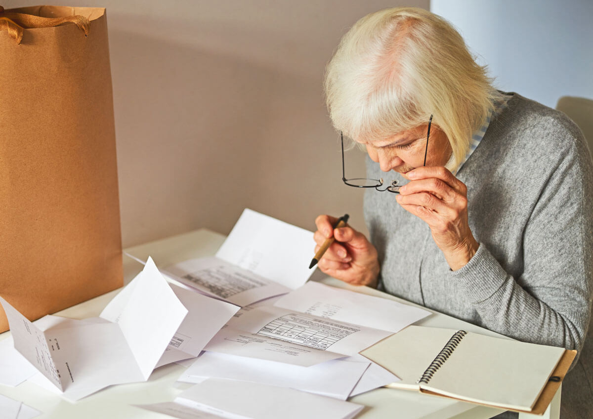 Eine Seniorin lehnt über der Stromrechnung
